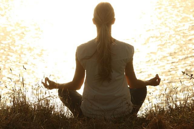 Silhouette of a serene figure meditating as morning light breaks through.